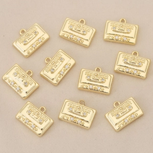 Detalle de 10 dijes de casete retro dorados con cristales para joyería artesanal