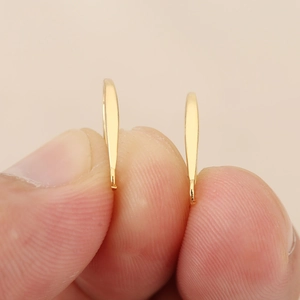 Primer plano de ganchos para oreja planos bañados en oro 18k con acabado brillante