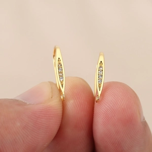 Detalle de ganchos para pendientes de hoja chapados en oro con circones para joyería DIY