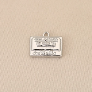 Detalle del colgante de casete de plata vintage con notas musicales y diamantes de imitación