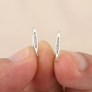 Vista macro detallada de pendientes bañados en oro de 18k con cinco circonitas graduadas