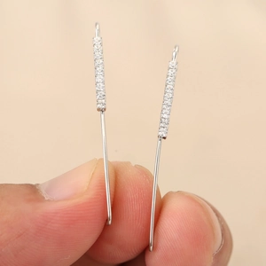 Dettaglio degli orecchini lineari placcati in oro 18k con intarsio in zirconi lucenti