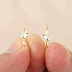 Nahaufnahme der 18k vergoldeten geometrischen Ohrhaken mit Zirkonia in Krallenfassung