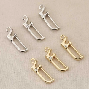 Vue détaillée de pendentifs géométriques creux avec placage or et argent et zircon