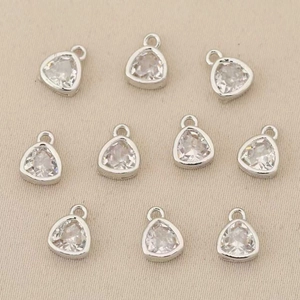 Macro detail of ten silver pendant connectors with clear zircon stones for DIY jewelry making