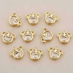 Detail of 10-piece gold plated tiger pendants with zircon inlay for DIY jewelry