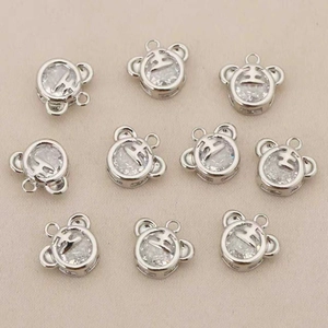 Detailed view of silver bear pendants featuring tiger-inspired crown engraving and clear zircon