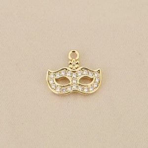 Macro detail of Bohemian mask pendant with 18k gold plating and shimmering zircons