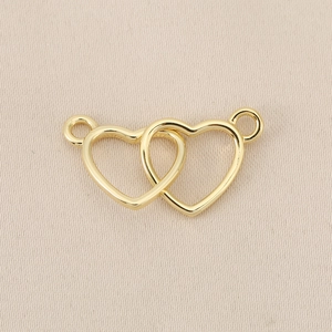 Vista detallada de colgantes de corazones entrelazados chapados en oro 18K con lazos dobles
