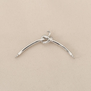 Détail macro d'une barre de connexion à nœud argenté avec deux boucles pour bijoux DIY
