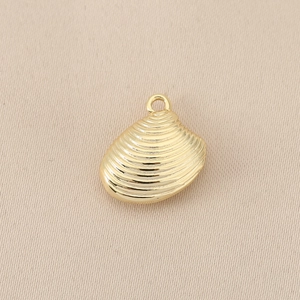 Detailed macro view of a golden shell pendant featuring elegant wavy textures for jewelry DIY