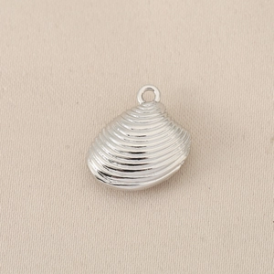 Macro shot of silver scallop shell charm with radial texture for DIY jewelry making
