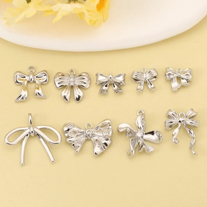 Nine assorted silver bow-knot metal pendants with hanging loops for DIY jewelry making