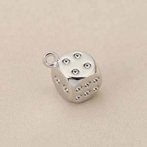 Macro-opname van zilveren dobbelsteen hanger met zirkoon voor DIY sieraden