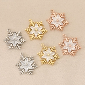 Detailed view of copper zircon snowflake charms in gold silver and rose gold finishes