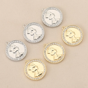 Macro-opname van 18K goud en zilveren muntpendants met reliëf en ingelegde zirkoon