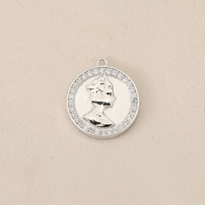 Detail van een ronde 18K vergulde hanger met Elizabeth II profiel en zirkonia-steentjes