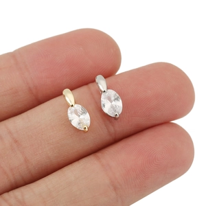 Mini-Markise-Kristallanhänger in Gold und Silber auf einer Fingerspitze gezeigt