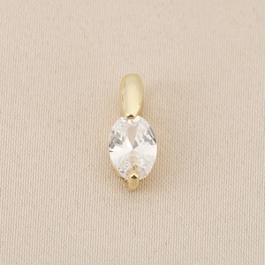 Detail von 18K vergoldetem Kupferanhänger mit ovalem Zirkonia auf beige Stoff