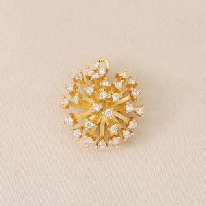 Macro detail of gold-plated sunburst pendant with micro-paved cubic zirconia