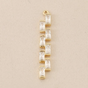 Detalle macro del colgante geométrico chapado en oro 18K con ocho circones rectangulares