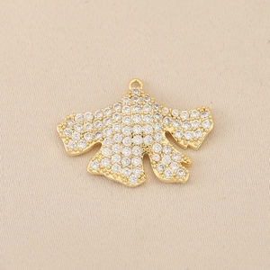 Detailaufnahme des 18K vergoldeten Kimono-Anhängers mit Zirkonia-Besatz auf beigem Stoff
