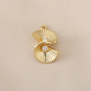 Dettaglio macro di un ciondolo geometrico in ottone placcato oro 18K con pietre di zircone