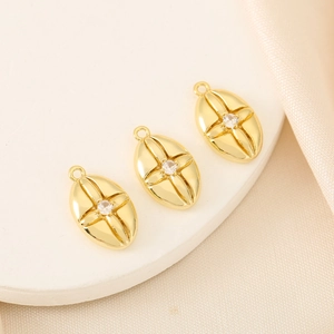 Three 18K gold plated oval starburst pendants with zircon inlay on a satin background
