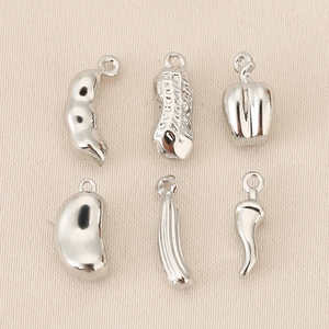 Detailed view of silver vegetable charms including peanut and chili for DIY jewelry making