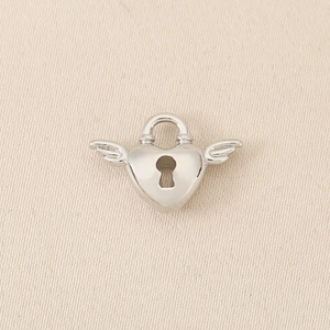 Detailed close-up of heart-shaped wing pendant in silver finish with keyhole motif