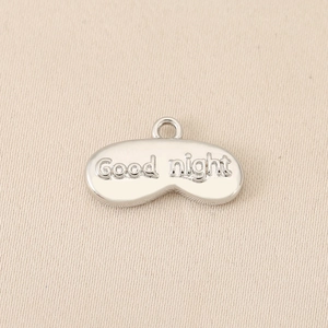 Détail macro du pendentif masque de nuit plaqué or 18K avec texte Good Night et fini mat