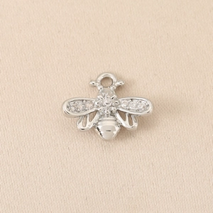 Makroaufnahme von Bienenanhänger mit Zirkonia-Steinen und feiner Metallverarbeitung