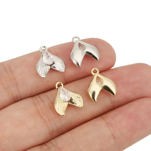 Detailed close-up of small fish tail pendant with zircon inlay for DIY jewelry crafting