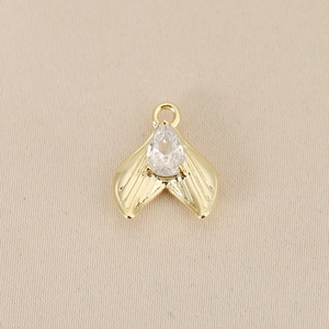 Detailed view of a gold-plated mermaid tail pendant with a large teardrop gemstone