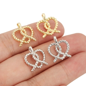 Vue macro des breloques bretzel dorées et argentées à texture torsadée pour bijoux DIY