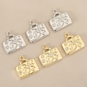 Golden and silver palm tree pendants with rhinestones on beige textured background