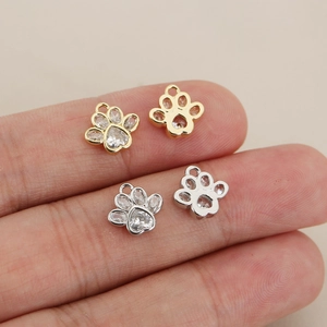 Macro shot of 18K gold plated paw pendants with clear zircons for jewelry making