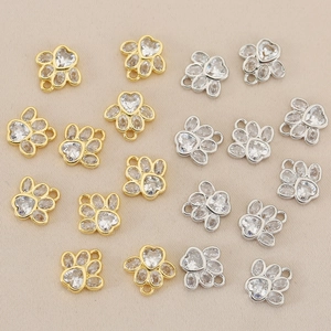Detailed view of copper gold-plated paw charms with cubic zirconia and heart center stones