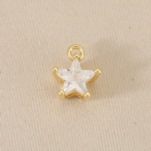 Macro shot of 18k gold star pendant with zircon stone and secure four-prong setting