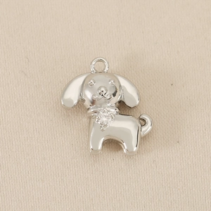 Dettaglio di un ciondolo a cucciolo d'argento con zircone lucido su tela beige