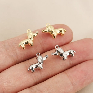 Macro shot of dachshund charms in gold and silver finish with tiny zircon stone inlays