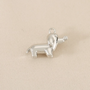 Detailed view of silver dachshund dog pendant with sparkling zircon on high-quality metal