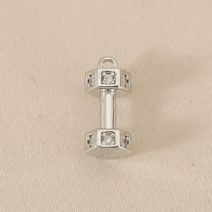 Macro shot of silver dumbbell jewelry pendant with sparkling cubic zirconia inlay