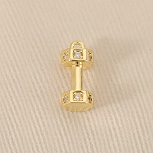 Macro detail of 18k gold plated dumbbell pendant with sparkling rhinestones for DIY jewelry