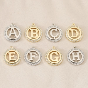 Detailed close-up of 18K gold and silver letter pendants A-H with sparkling stones