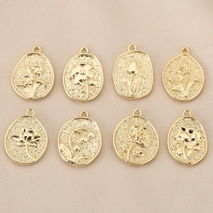 Detailed flat lay of eight 18K gold plated floral relief pendants for DIY jewelry making