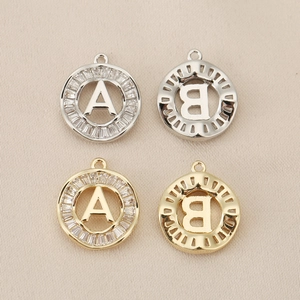 Macro view of 18K gold and silver letter A and B pendants with inlaid cubic zirconia stones