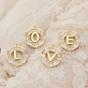 Detail of four 18K gold-plated LOVE alphabet pendants with zircon pave for DIY jewelry making