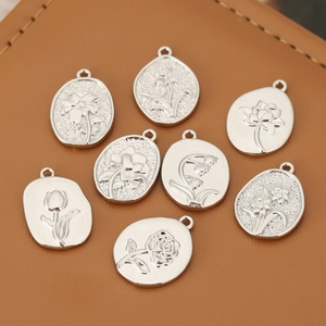 Detailed macro view of eight silver floral relief pendants on brown leather background