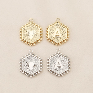 Macro shot of 18K gold and silver hexagonal letter pendants for custom DIY jewelry